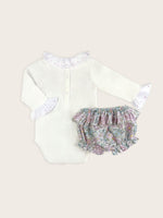 Pink dots embroidered onto the frilled collar and cuffs of a white bodysuit paired with floral bloomers rear view.