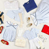 Little Collins Clothing Nautical Boy 2 Piece Set with white double breasted button up shirt and blue and white striped shorts laid out with other items from the nautical range