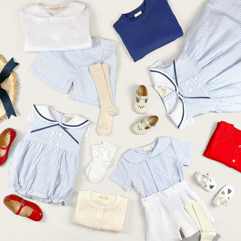Little Collins Clothing Nautical Boy 2 Piece Set with white double breasted button up shirt and blue and white striped shorts laid out with other items from the nautical range